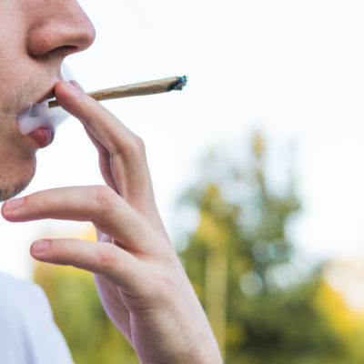 The Young Person Smoking Medical Marijuana Joint Outdoors. The Y The Young Person Smoking Medical Marijuana Joint Outdoors. The Y