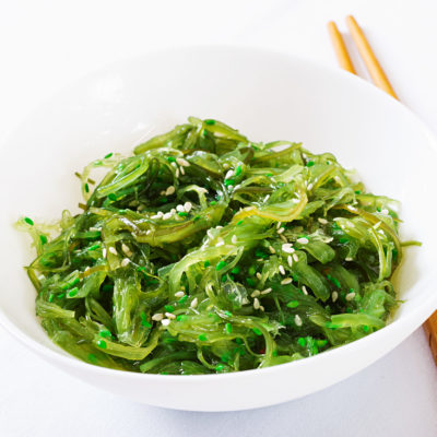 Wakame Chuka Or Seaweed Salad With Sesame Seeds In Bowl On White Background Wakame Chuka Or Seaweed Salad With Sesame Seeds In Bowl On White Background
