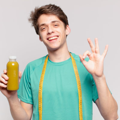Young Teenager Man Happy Expression And Holding A Soothy. Diet Concept Young Teenager Man Happy Expression And Holding A Soothy. Diet Concept